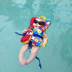 Figure No.3: an infant floating in pool with the help of Infant Life Jacket